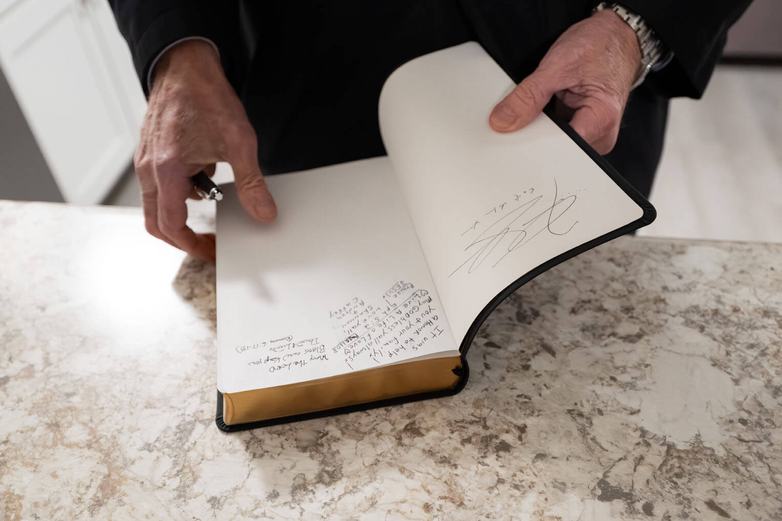 Graham signs a Bible to be given to a new homeowner.