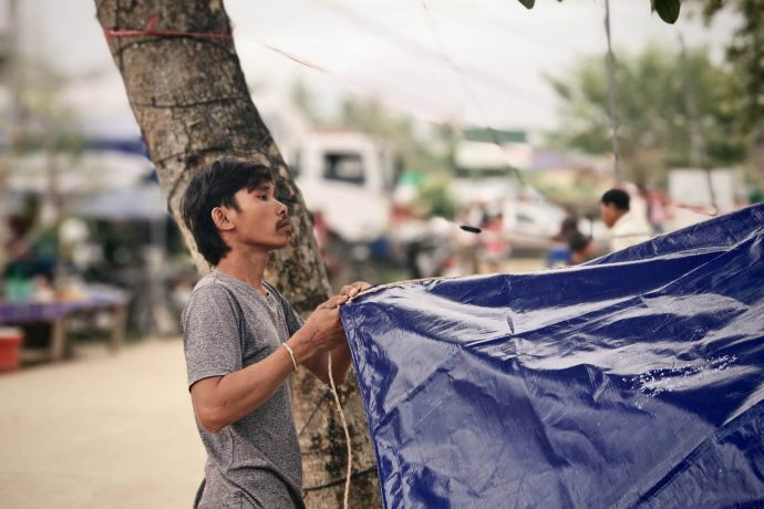 A man puts up his Samaritan's Purse tarp at the displacement camp.