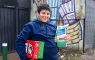 boy in Chile with shoebox and The Greatest Journey materials