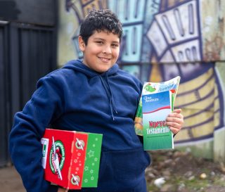 boy in Chile with shoebox and The Greatest Journey materials