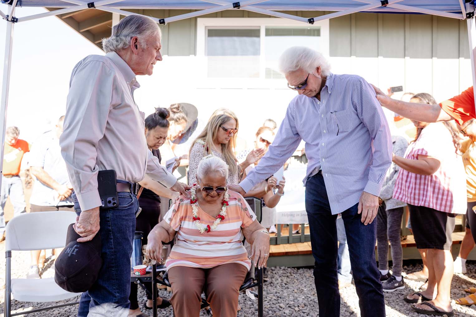 Franklin Graham joins staff and volunteers in praying with Aunty Keala during the dedication of her new home.