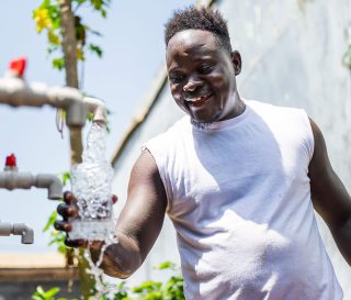 Liberian inmate fills his bottle with clean drinking water from a system provided by Samaritan's Purse at Monrovia Central Prison.