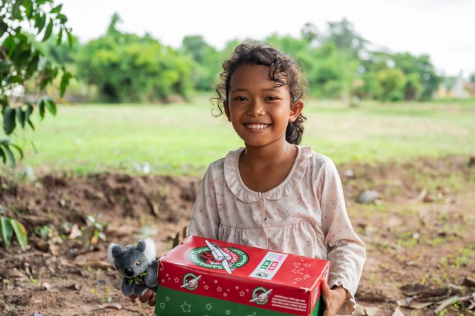 Girl smiling with shoebox gift