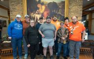 disabled adults in front of painting of the Good Samaritan