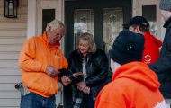 Volunteers open Bible with homeowner