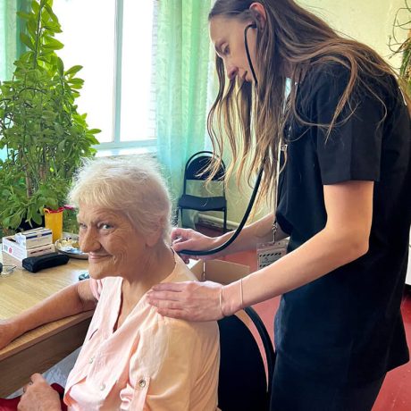 Mobile Medical Unit nurse checks Maria's lungs