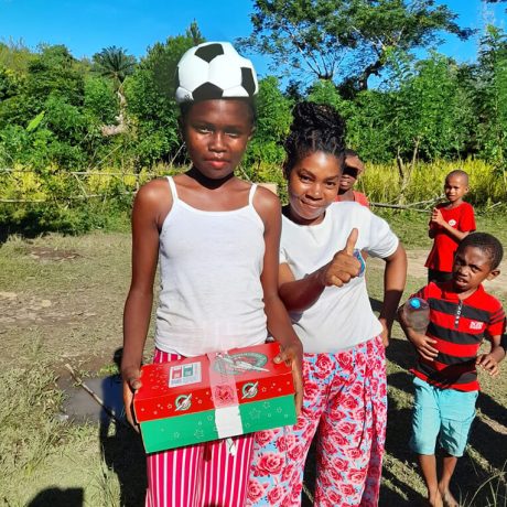 children with a shoebox gift and soccer ball