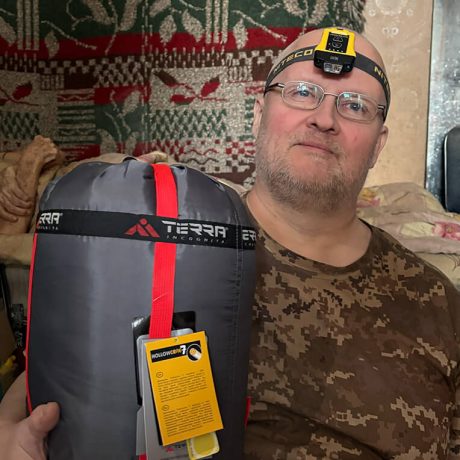 Andriy holds sleeping bag he received from Samaritan's Purse