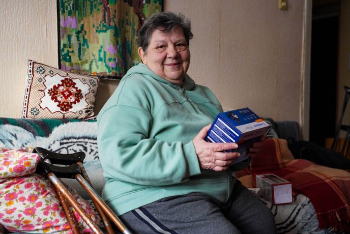 Maria holds some of her emergency supplies with her crutches by her side