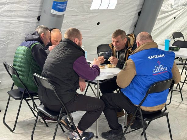 Billy Graham chaplain sits at table with men