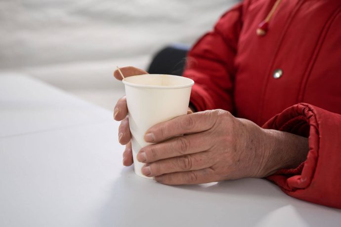 Anna's hands hold a cup of something warm