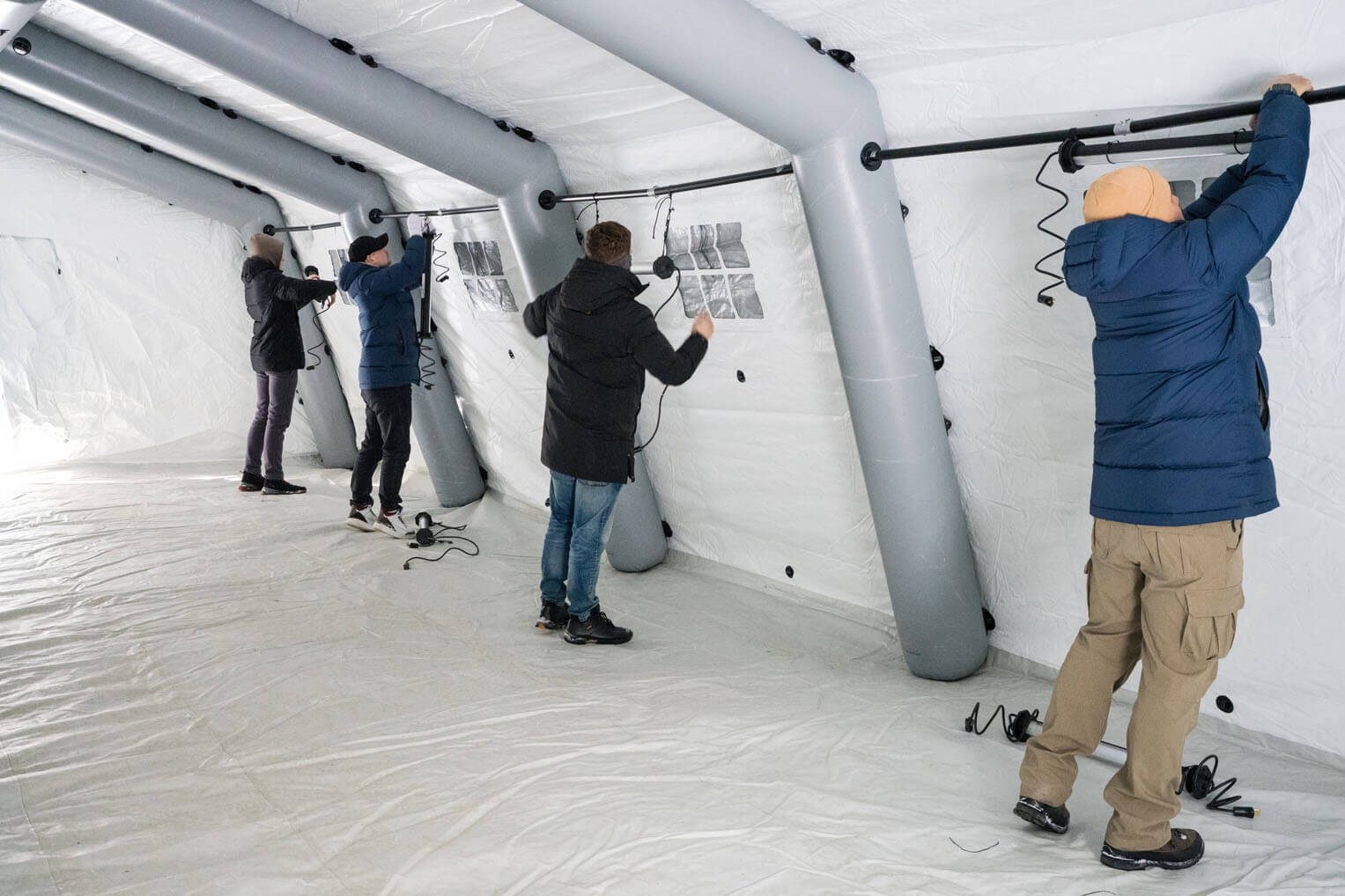 Four people install lights inside warming center