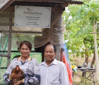 Cambodian couple in front of their chicken coop