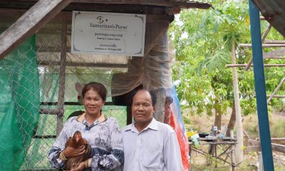 Cambodian couple in front of their chicken coop