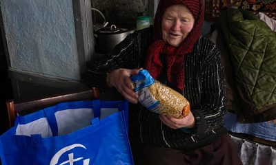 Hanna smiles as she opens a bag of groceries from Samaritan's Purse