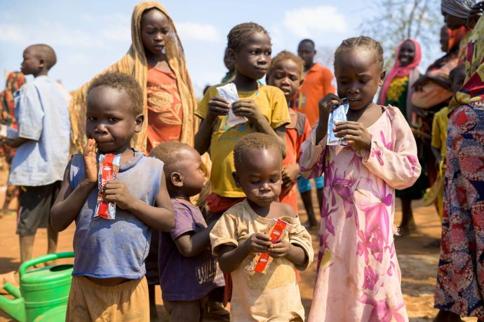 Children feed on packs of nutrient-dense food provided by Samaritan's Purse at a displacement camp in Sudan. 
