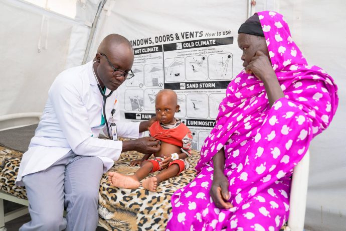 Toma, right, and her grandson, Ahmed, are seen by Dr. Rodgers as our staff nurture the little boy back to full health. 