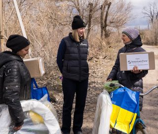 Samaritan's Purse staff visit with Vira and provide her with agricultural supplies