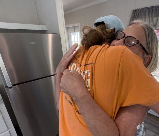 Andrea Green embraces a Samaritan's Purse rebuild team member as she celebrates her new home.