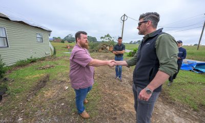 Edward Graham greets a Mississippi homeowner in front of his home. They shake hands.