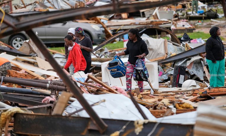 People move through the debris in tornado-hit Mississippi.