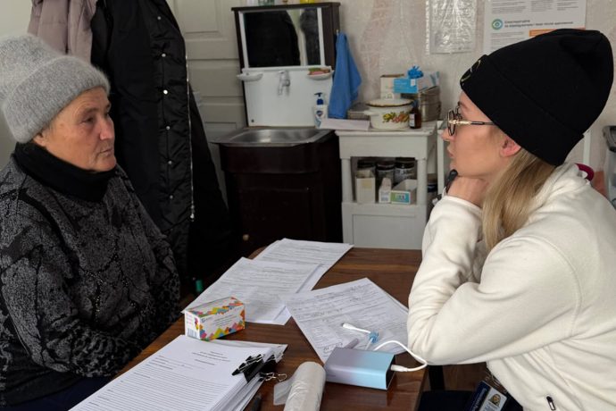 Oksana being seen by a member of the mobile medical unit staff