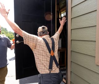 homeowner throws up his hands in delight when Samaritan's Purse foreman opened the door to his new home for the first time
