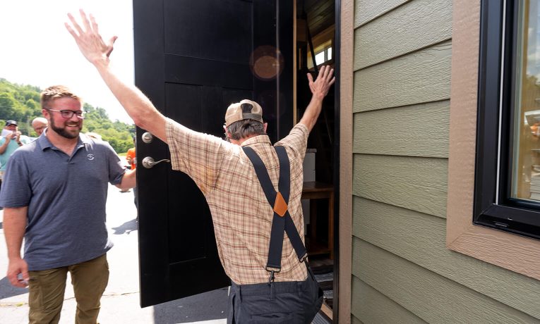 homeowner throws up his hands in delight when Samaritan's Purse foreman opened the door to his new home for the first time