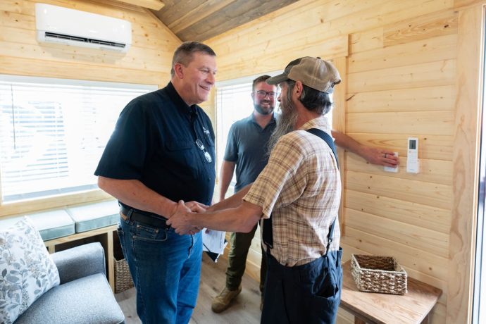 Luther Harrison shakes Brian Baker's hand inside his new home