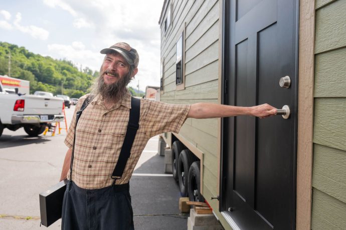 Brian smiles as he is about to open the door of his home