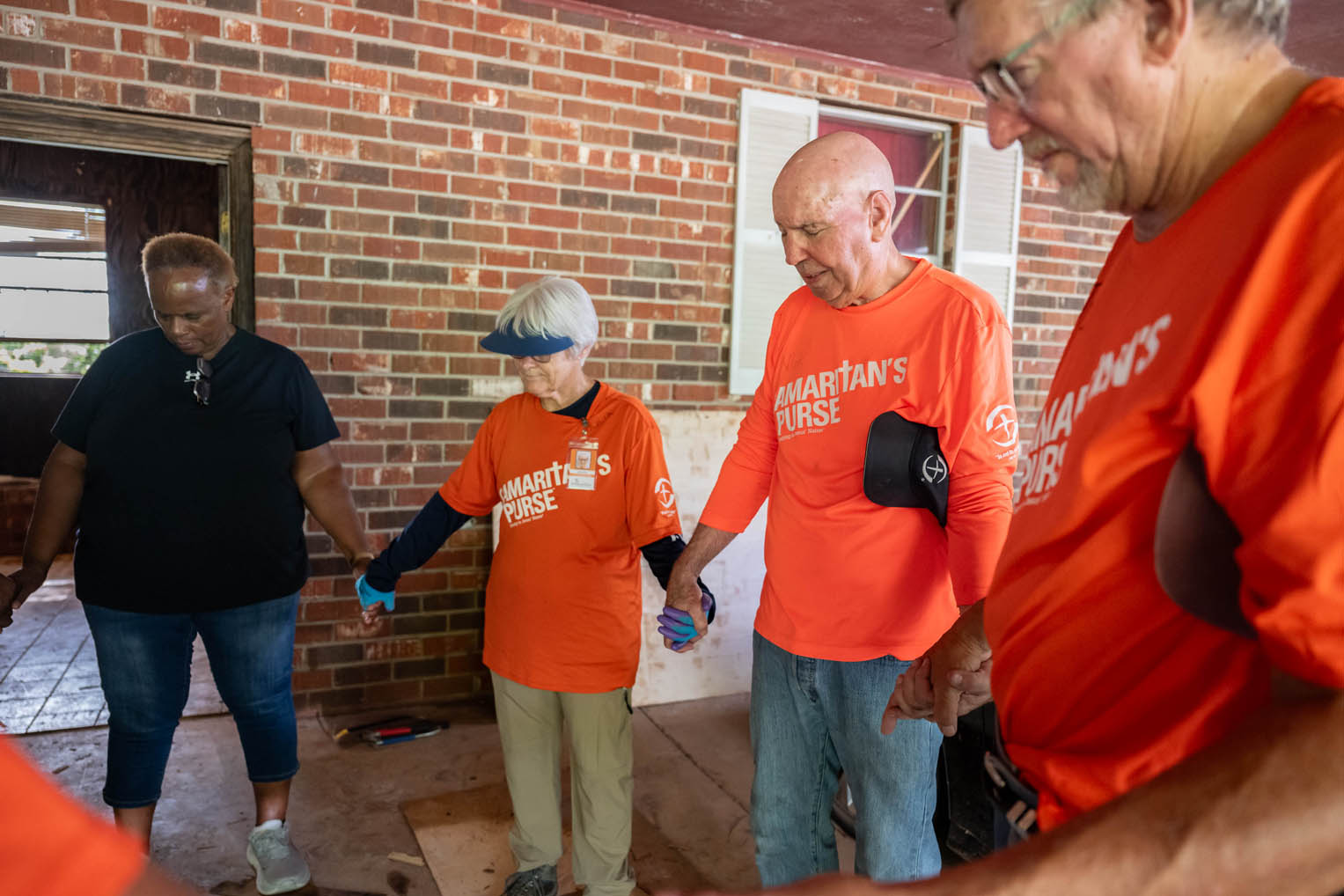 Volunteers pray with a homeowner after work on their home.