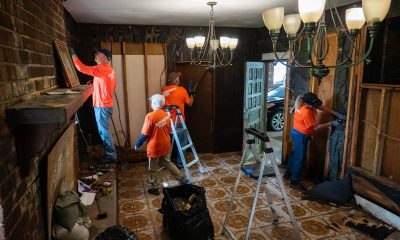 Volunteers in Samaritan's Purse orange shirts clean up a flooded den in a house in Louisiana.