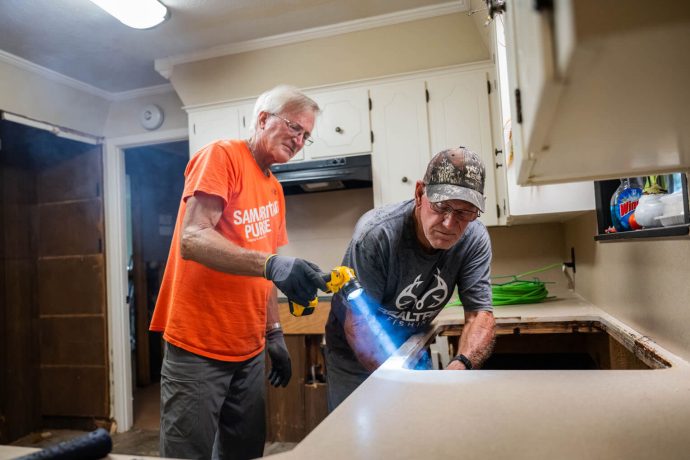 A volunteer helps Wallace Morgan in his kitchen