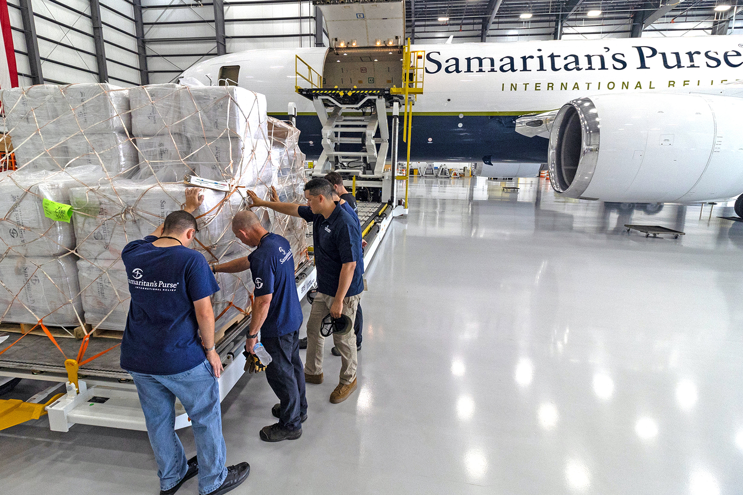 Miembros del equipo oran por los suministros de socorro que luego transportamos por vía aérea a Venezuela.