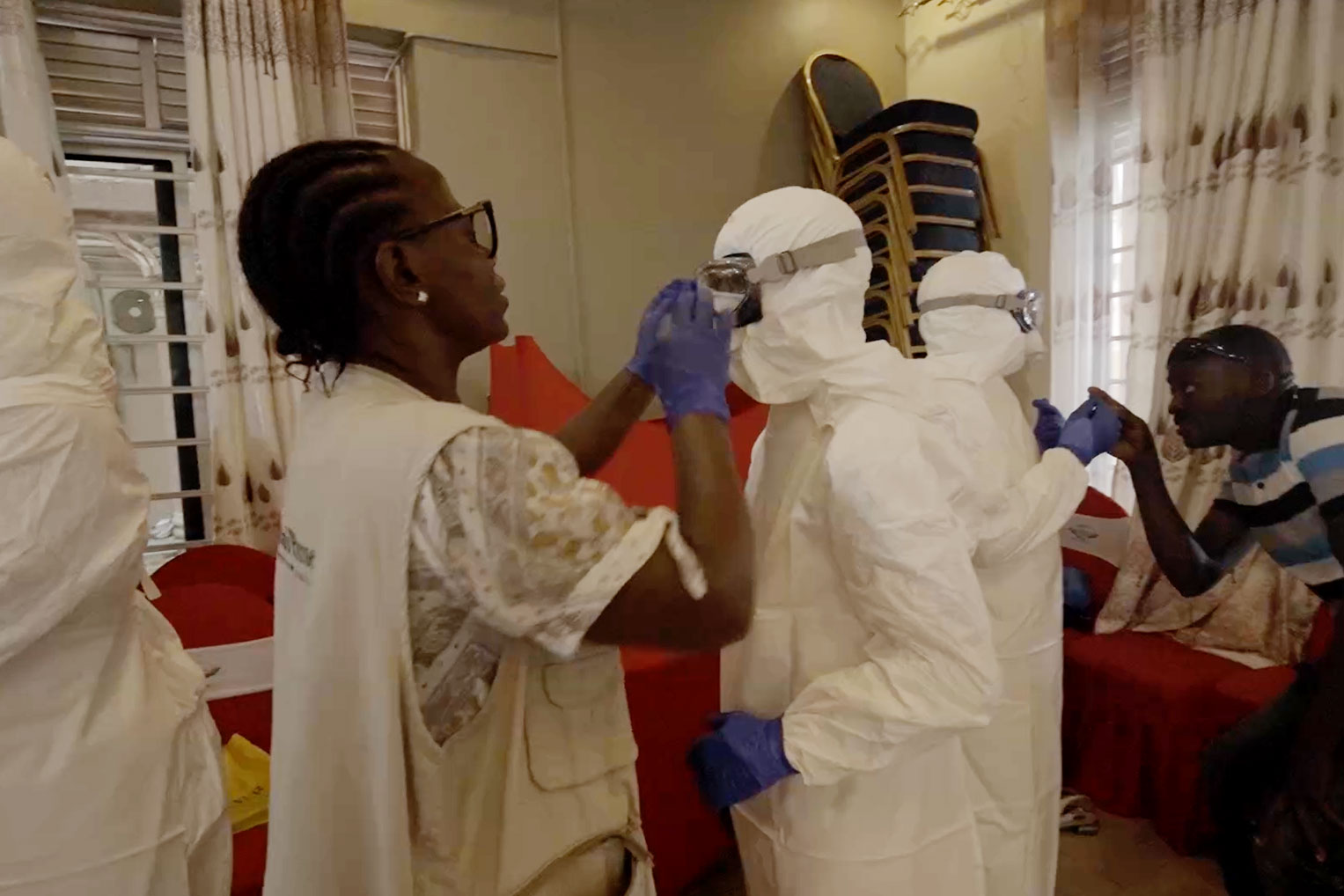 A Samaritan's Purse WASH staff member helps a trainee secure protective eyewear.