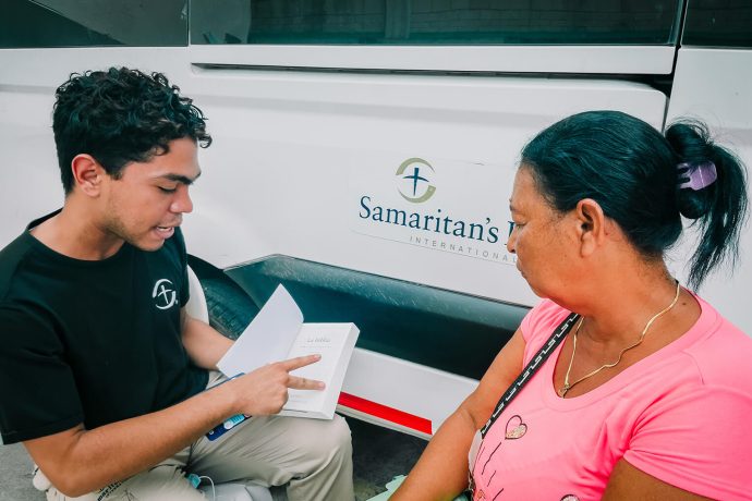 Samaritan's Purse staff shows Liliana her new Bible. Each patient goes home with a Bible after their first consultation at our treatment centers.
