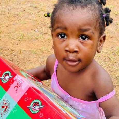 Young girl clutches her shoebox gift