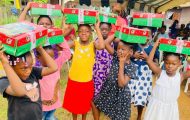group of girls from Gabon holding shoebox gifts on top of their heads