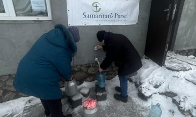 Ukrainians collect water at a church tap