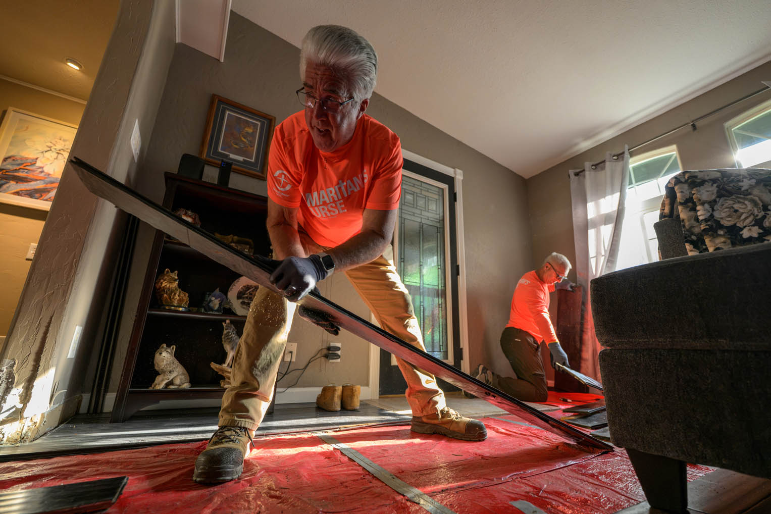 Volunteers removed molding floor boards and many ruined valuables from John's home.
