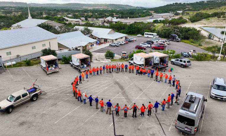 Volunteers and chaplains circle up to pray before serving homeowners in our 2025 flood response to Kerr County, Texas