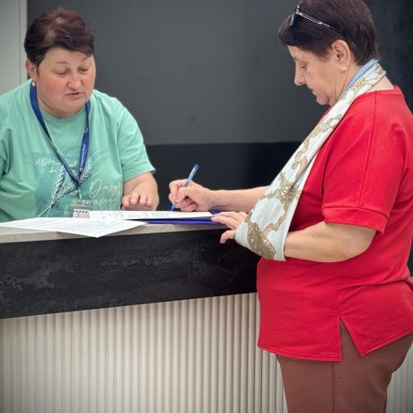 Nadia does paperwork with her hand in a sling