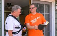 Volunteer presents Bible to homeowner
