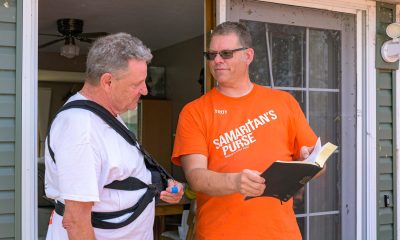 Volunteer presents Bible to homeowner
