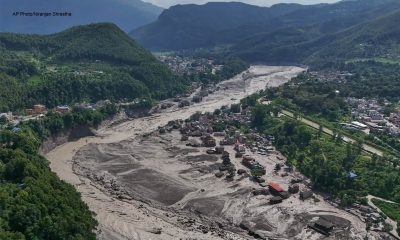 Damaged houses stand precariously near the swollen, debris-choked banks of the Trishuli River after flash floods in Nepal's Nuwakot district on Wednesday, Aug. 26, 2026. (AP Photo/Niranjan Shrestha)