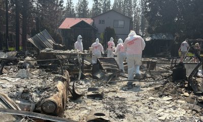 Volunteers suited in protective clothing search through ashes in Spokane.