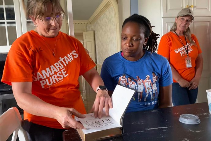 Volunteer opens Bible for Khadija