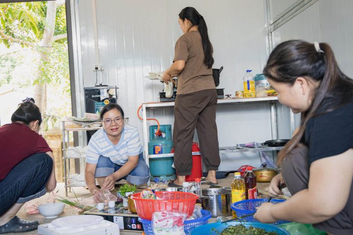 Tu prepares a meal on the floor