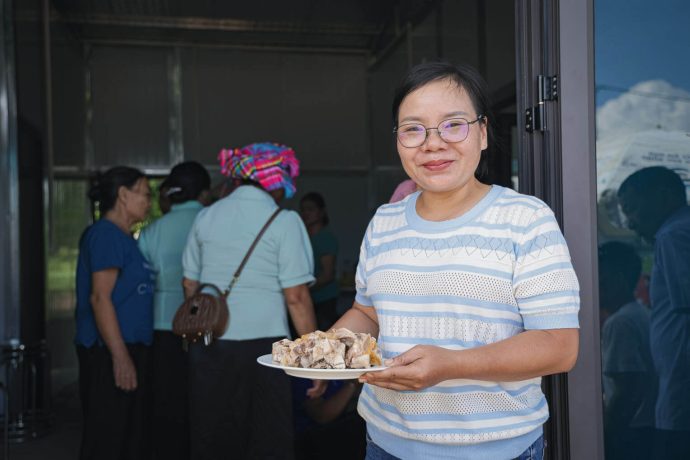 Tu smiles while holding a plate of food supplied by Samaritan's Purse