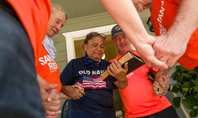 Volunteers pray with a flood survivor in Uvalde County, Texas, after helping cleaning out her home.